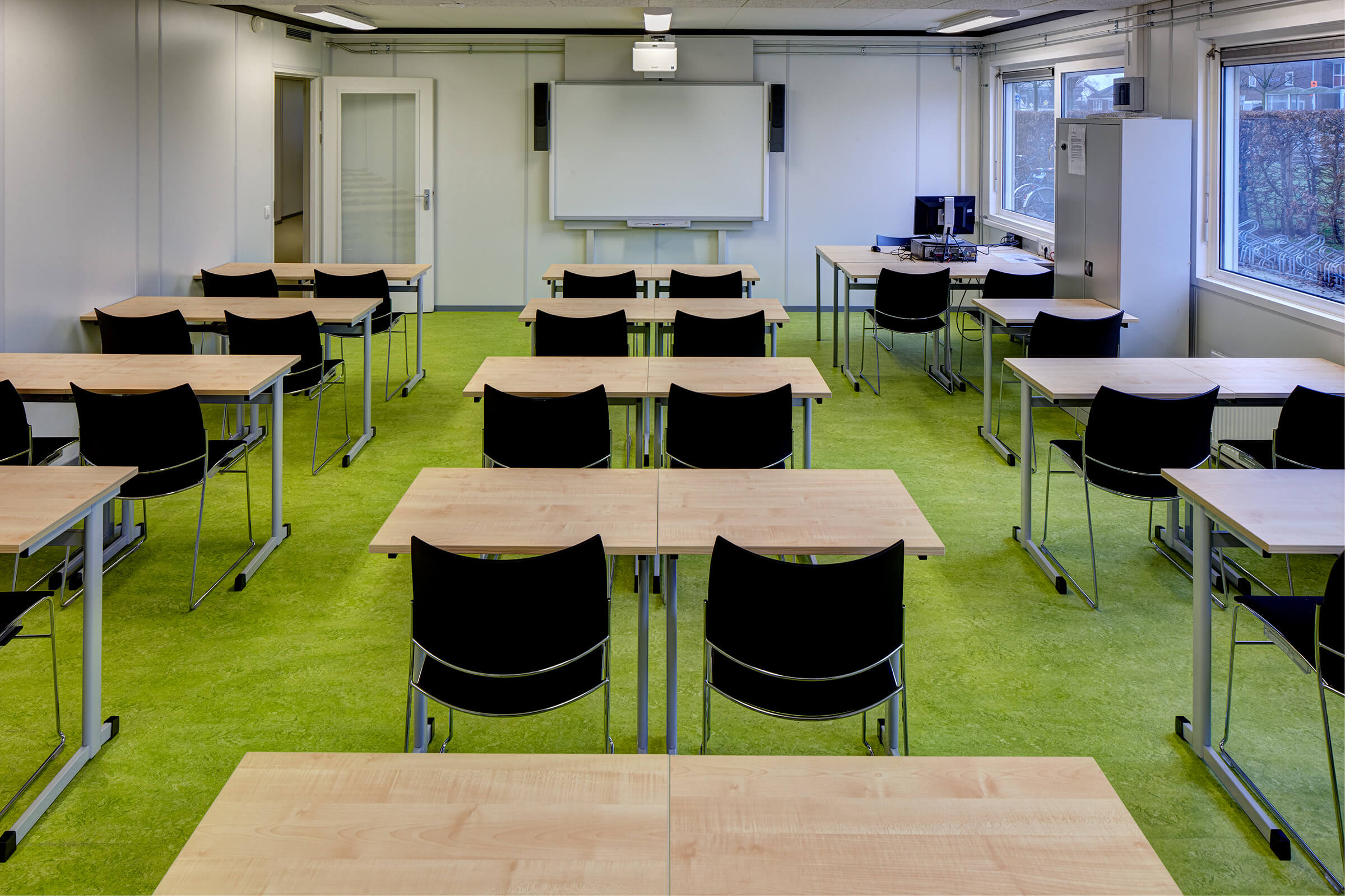 Les salles de classe temporaires étaient meublées de chaises Curvy noires et de tables basiques. 