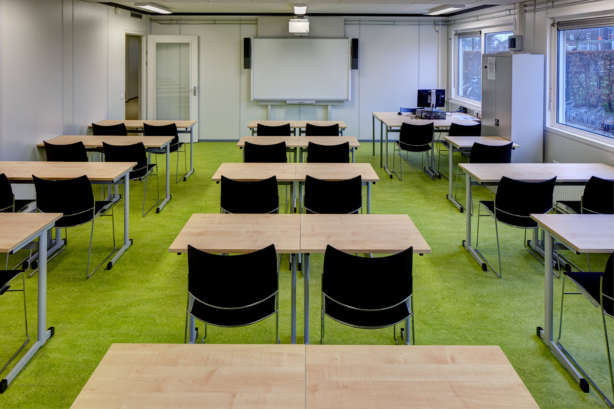 Les salles de classe temporaires étaient meublées de chaises Curvy noires et de tables basiques.